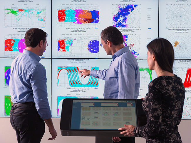 People discussing forecast products on ECMWF's weather wall